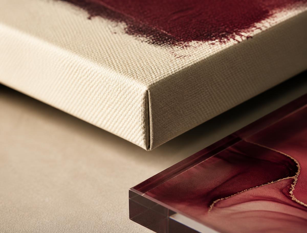 Macro detail of a stretched canvas print edge beside an acrylic panel