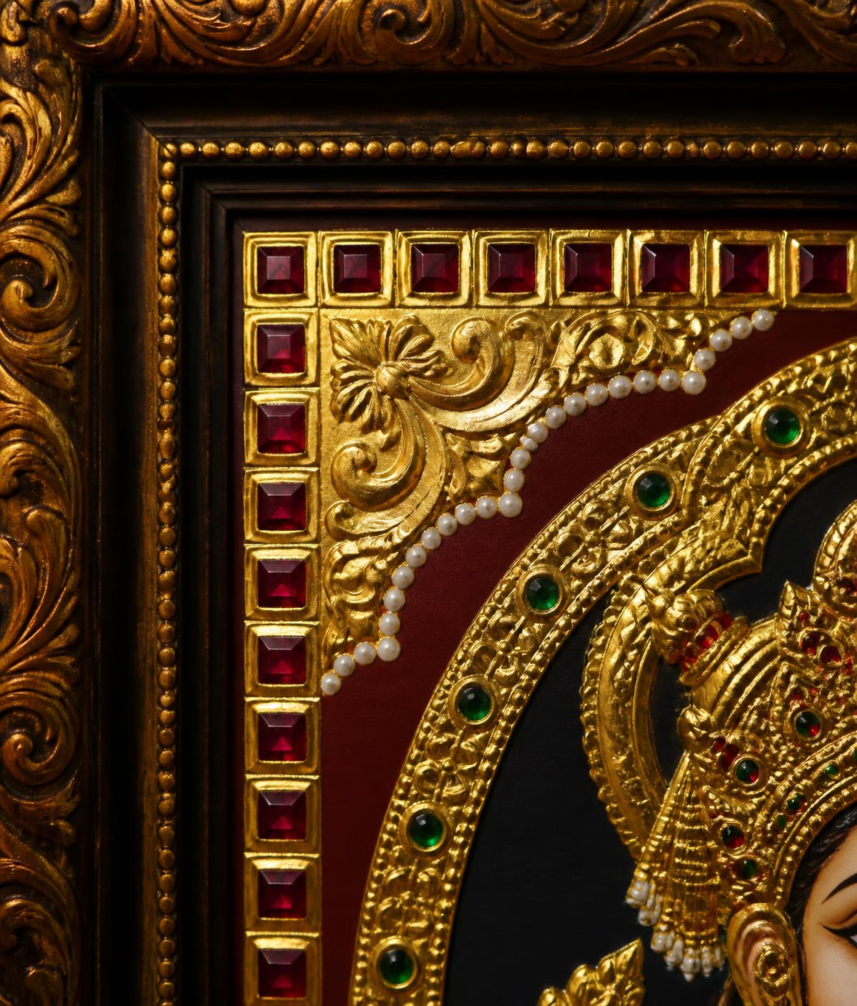 Gold leaf Tanjore artwork detail inside an ornate carved frame